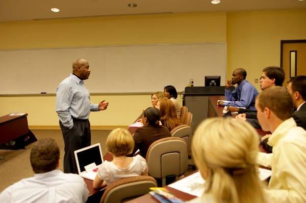 Male professor teaching students in a classroom.
